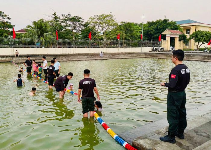 Các em nhỏ hào hứng tham gia học bơi dưới sự hướng dẫn của các sĩ quan GGHB Bộ Công an tại bể bơi dân sinh xã Hoàng Hoa Thám.