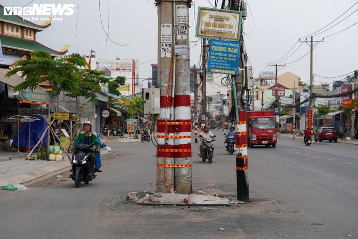 Để cảnh báo cho người tham gia giao thông, đơn vị thi công đã sử dụng băng keo và sơn phản quang quấn quanh các trụ điện. Tuy nhiên, đây chỉ là giải pháp tạm thời trong thời gian chờ hoàn tất việc di dời.