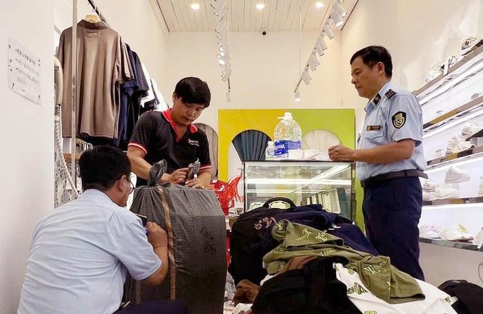 Lực lượng chức năng kiểm tra sản phẩm giả mạo thương hiệu nổi tiếng tại một hộ kinh doanh ở phường Từ Liêm. Ảnh: Hoài Nam