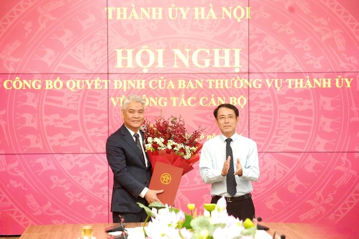 Phó Bí thư Thường trực Thành ủy Hà Nội Nguyễn Trọng Đông trao quyết định của Ban Thường vụ Thành ủy và tặng hoa chúc mừng đồng chí Phạm Quang Hưng nhận nhiệm vụ mới. Ảnh: Phạm Hùng