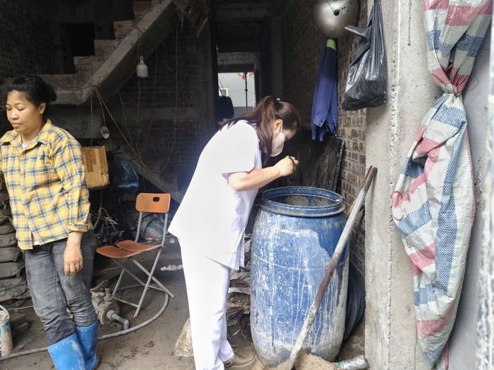Cán bộ y tế phường Phú Thượng kiểm tra, loại bỏ các ổ bọ gậy phát sinh trong khu vực người dân sinh sống. Ảnh: Tuệ Lâm
