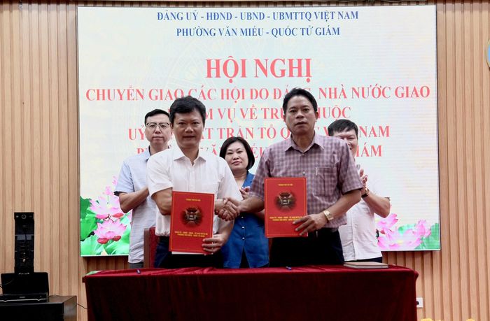Chủ tịch UBND phường Văn Miếu - Quốc Tử Giám Hà Anh Tuấn và Chủ tịch Ủy ban MTTQ Việt Nam phường Mai Văn Lâm ký kết bàn giao. Ảnh: An Quyên.