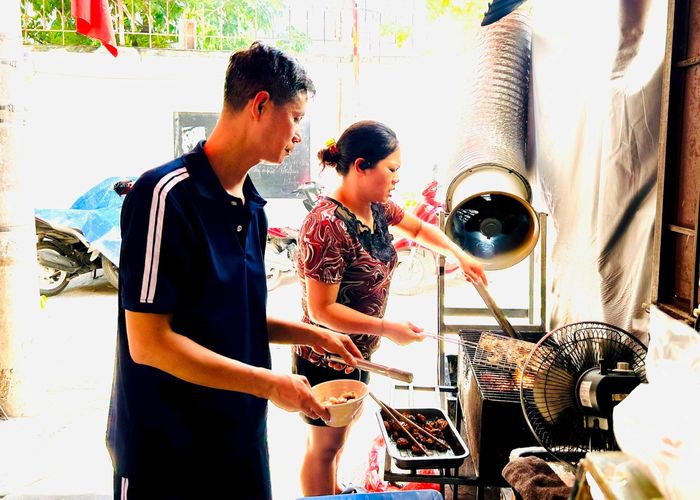 Vợ chồng chị Đoàn Thị Thu Thủy nướng thịt để phục vụ khách ăn bún chả. Ảnh: Trần Oanh.