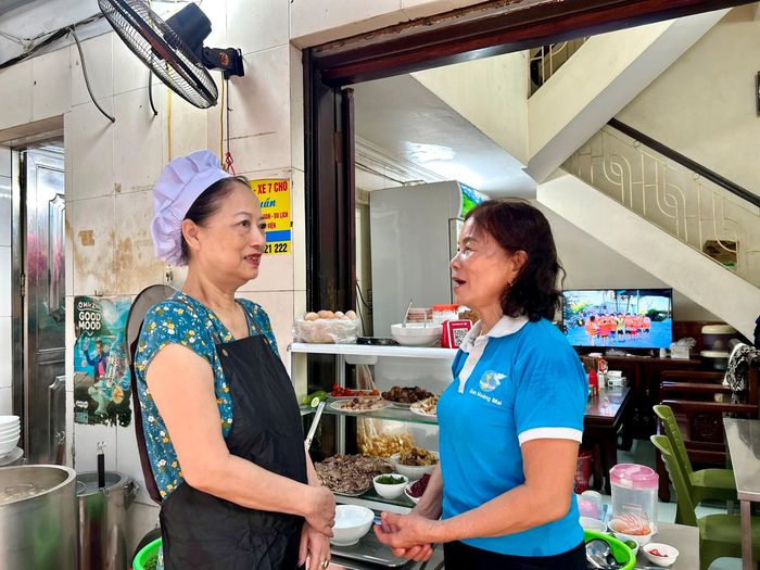 Chi hội trưởng Chi hội Phụ nữ Tổ dân phố số 8 Lê Thị Thanh Hoa (bên phải) trao đổi với bà Vũ Thị Thanh Vân về tình hình bán hàng phở. Ảnh: Trần Oanh.