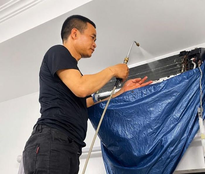 Anh Lê Bùi đang vệ sinh điều hòa cho khách hàng. Ảnh: NVCC.
