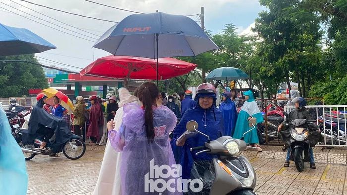 Tại các điểm thi, đa số thí sinh và phụ huynh có mặt từ sớm dù trời mưa nặng hạt.
