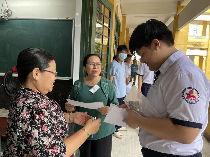 Các giám thị làm thủ tục vào phòng thi với các thí sinh. Ảnh: Đ.Xá.