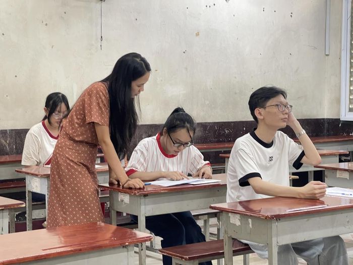 Các thí sinh đối chiếu thông tin cá nhân, số báo danh lần cuối trước khi bắt đầu kỳ thi. Ảnh: Đ.Xá.