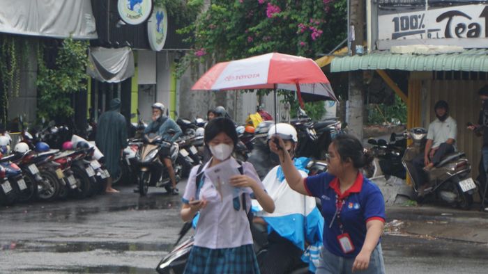  Các tình nguyện viên hỗ trợ thí sinh vào điểm thi. Ảnh: NGUYỄN QUYÊN 