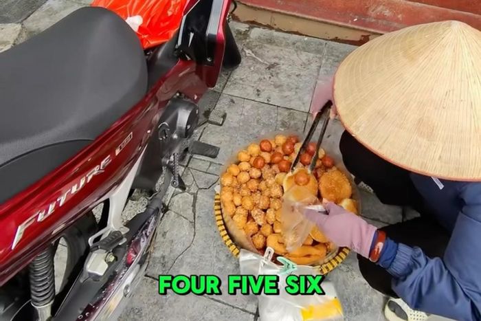 Người phụ nữ bán hàng rong "hét giá" du khách quốc tế mua 10 chiếc bánh rán. Ảnh: Cắt từ video.