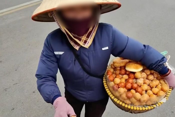 Người phụ nữ bán cho khách Tây 10 chiếc bánh rán với giá 430.000 đồng ở hồ Gươm. Ảnh: Cắt từ video.