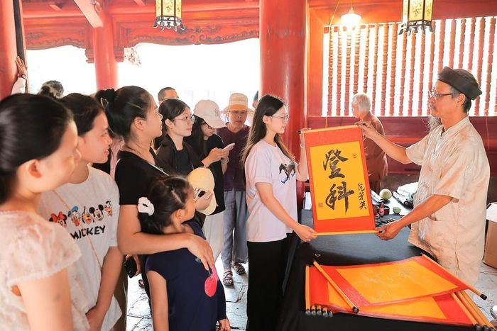 Nhiều học sinh và phụ huynh đến Văn Miếu - Quốc Tử Giám (Hà Nội) xin chữ, cầu mong may mắn và đạt kết quả tốt trong kỳ thi sắp tới. Ảnh: Lê Đông - TTXVN