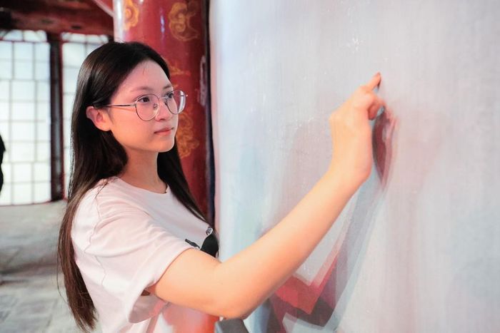 Học sinh ghi lại ước vọng của bản thân tại khu vực tường Văn Miếu - Quốc Tử Giám, mong muốn hoàn thành tốt Kỳ thi tốt nghiệp THPT năm 2026. Ảnh: Lê Đông - TTXVN