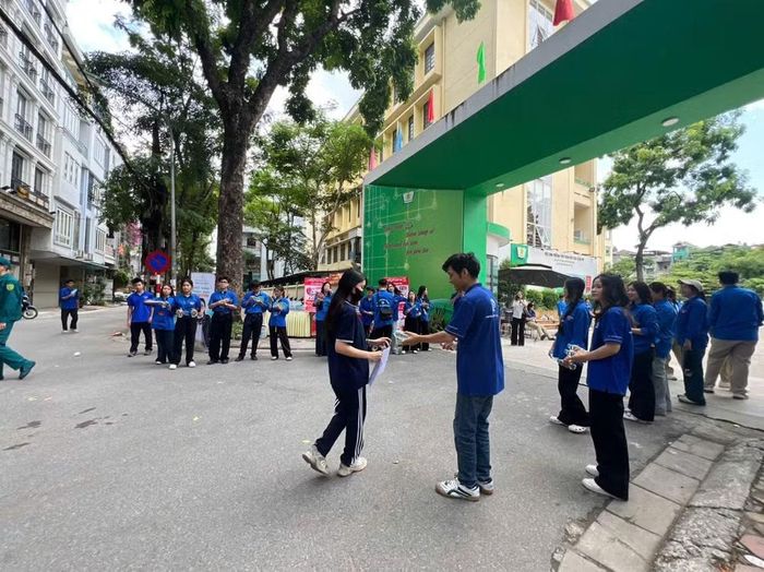 Sinh viên tình nguyện trao cho mỗi học sinh một chai nước trước khi vào điểm thi.