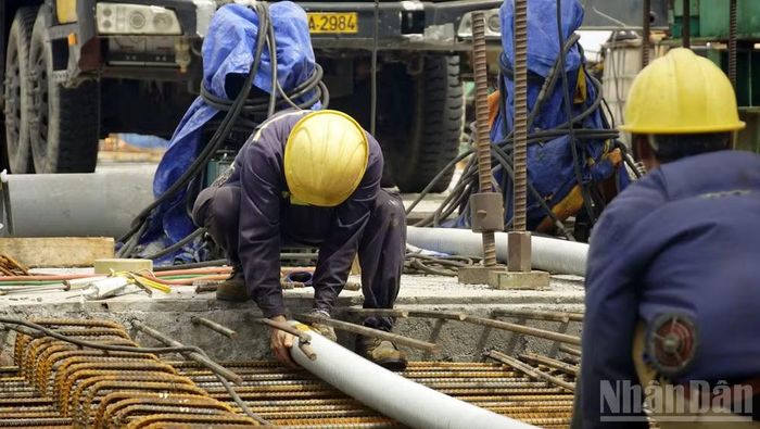 Công nhân đang lắp đặt vật liệu để chuẩn bị hợp long hai nhịp biên.