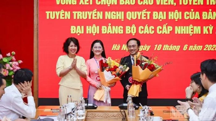 Đồng chí Nguyễn Thị Hoàng Vân, Phó Bí thư Đảng ủy các cơ quan Đảng Trung ương tặng hoa chúc mừng 2 báo cáo viên, tuyên truyền viên được chọn tham dự Hội thi báo cáo viên, tuyên truyền viên giỏi toàn quốc năm 2026 khu vực phía bắc. (Ảnh: BẢO LONG)