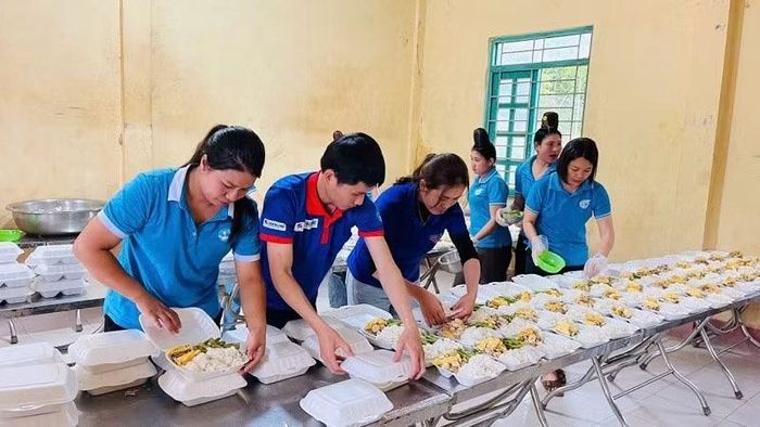 Các anh chị tình nguyện viên cẩn thận chuẩn bị từng suất ăn cho các em học sinh tại Nà Hỳ.