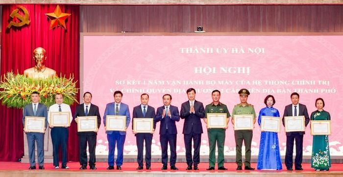 Trưởng Ban Tổ chức Trung ương Nguyễn Duy Ngọc cùng Ban Thường vụ Thành ủy Hà Nội khen thưởng các tập thể có thành tích xuất sắc tại hội nghị. Ảnh: TTXVN