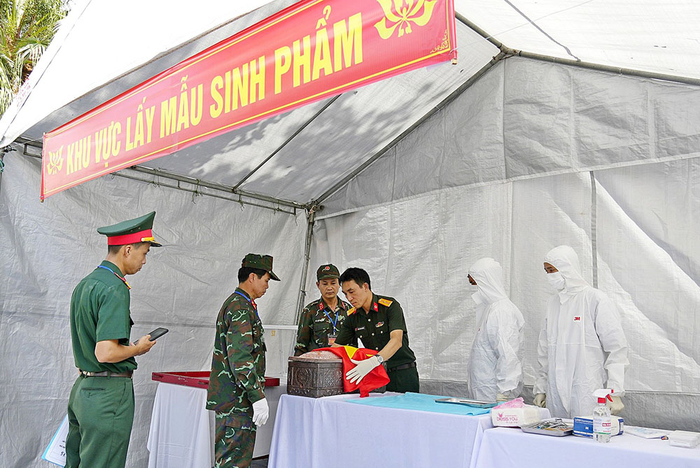 Lực lượng chức năng thực hiện lấy mẫu sinh phẩm phục vụ giám định ADN tại Nghĩa trang Liệt sĩ Nghĩa Trung, xã Tư Nghĩa, tỉnh Quảng Ngãi.