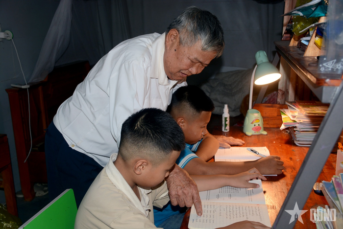 Anh hùng LLVT nhân dân Trần Quang Khải chỉ bảo các cháu nội học bài. 