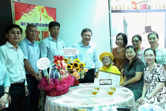  Đoàn lãnh đạo TPHCM, lãnh đạo phường Tân Thuận chụp hình lưu niệm cùng cụ Tới và gia đình 