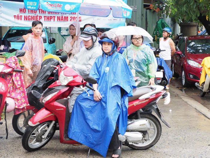  Phụ huynh chờ đón con dưới cơn mưa nặng hạt tại điểm thi THPT Gia Định. Ảnh: THU TÂM 