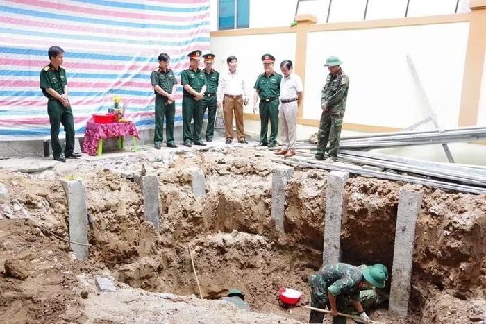 Lực lượng chức năng đang tiến hành cất bốc, quy tập các hài cốt liệt sĩ.