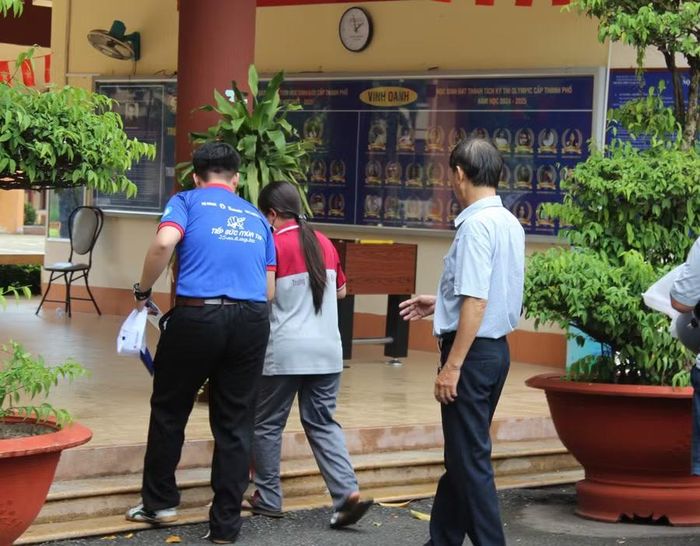 Thí sinh N. được hỗ trợ tại điểm thi Trường THPT Tạ Quang Bửu trong buổi làm thủ tục dự thi.