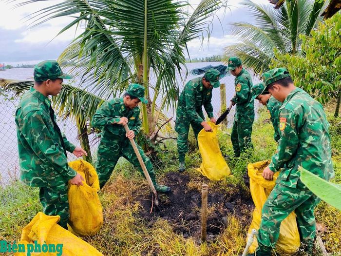 Cán bộ, chiến sĩ Đồn Biên phòng Vĩnh Gia giúp dân đắp đê chống lũ. Ảnh: Hồng Nam