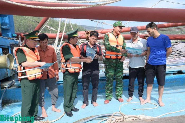 Cán bộ Bộ đội Biên phòng tỉnh Nghệ An phát tờ rơi tuyên truyền phòng, chống khai thác IUU cho ngư dân. Ảnh: Hải Thượng