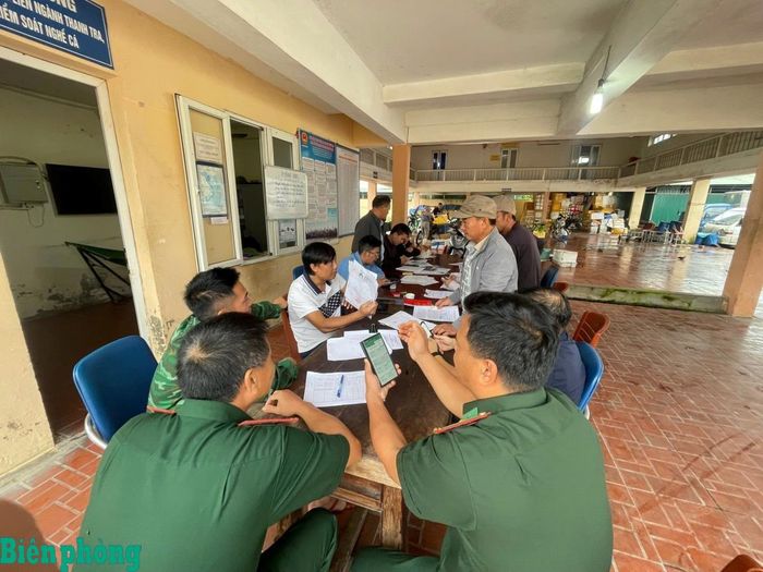 Cán bộ Bộ đội Biên phòng tỉnh Nghệ An và các đơn vị liên quan hướng dẫn người dân cài đặt ứng dụng eCDT VN trên điện thoại. Ảnh: Hải Thượng