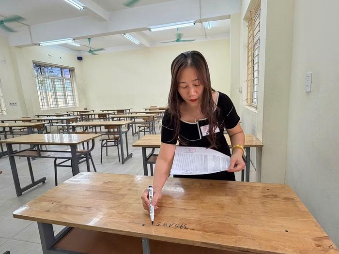 Giám thị đánh số báo danh trước khi gọi thí sinh vào phòng làm thủ tục.