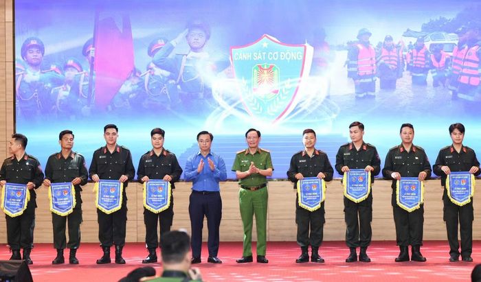 Đại tá Nguyễn Văn Trầm và anh Nguyễn Đức Nguyên trao Cờ lệnh cho các đội hình tình nguyện.