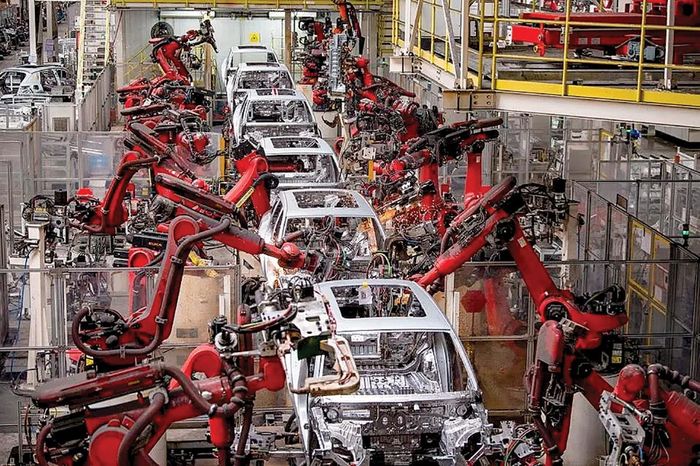 Các cánh tay robot điện đang hoạt động trên dây chuyền lắp ráp xe điện tại Trung Quốc