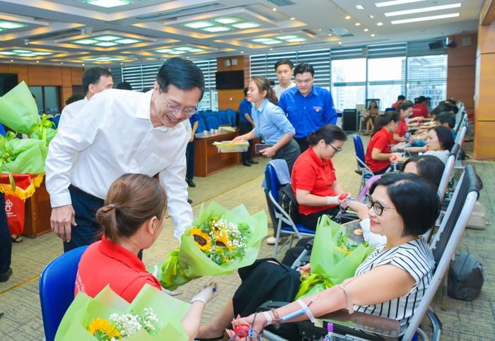 Phó Bí thư Thường trực Đảng ủy Petrovietnam Trần Quang Dũng tặng hoa động viên người lao động và cán bộ y tế tham gia Ngày hội hiến máu tình nguyện "Nhiệt huyết Petrovietnam" năm 2026.