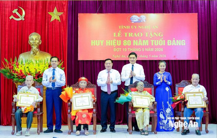 Các đồng chí trong Thường trực Tỉnh ủy trao Huy hiệu 80 năm tuổi Đảng và tặng hoa chúc mừng các đảng viên nhận Huy hiệu 80 năm tuổi Đảng. (ông Trần Đình Niêm ngồi ngoài cùng bên trái).Ảnh: PB