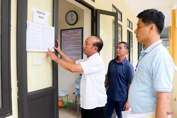 Cán bộ làm nhiệm vụ tại điểm thi Trường THPT Nguyễn Văn Trỗi kiểm tra niêm yết nội quy, quy chế trước các phòng thi.