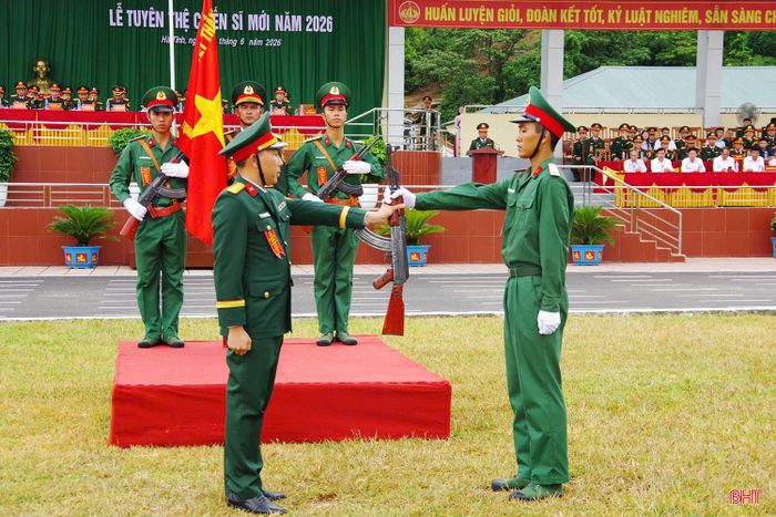 Chiến sĩ mới tiếp nhận vũ khí từ chỉ huy đơn vị.