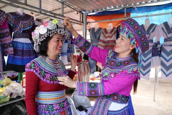 Du khách trải nghiệm mặc trang phục truyền thống của đồng bào Mông tại chợ phiên Đắk R’măng (xã Tà Đùng, tỉnh Lâm Đồng). (Ảnh: Nguyễn Huy Thành/TTXVN)