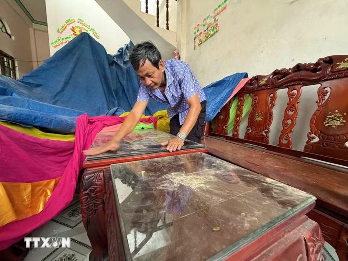 Dù đã khóa kín cửa nhưng bụi vẫn bám đầy trong nhà anh Nguyễn Thanh Liêm ở thôn Minh Tân Bắc, xã Mỏ Cày, tỉnh Quảng Ngãi. (Ảnh: Cao Nguyên/TTXVN)