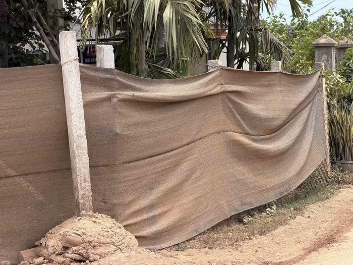 Vì quá bụi, người dân phải “khẩu trang” bằng lưới cho hàng rào nhà. (Ảnh: Cao Nguyên/TTXVN)