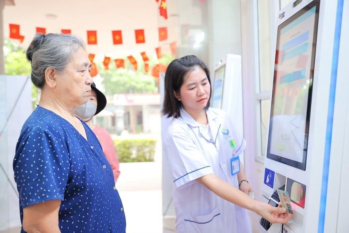 Nhân viên y tế phường Việt Hưng hướng dẫn người dân đăng ký khám bằng thẻ CCCD. (Ảnh: Minh Quyết/TTXVN)