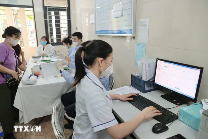 Nhân viên y tế Trạm Y tế phường Bạch Mai cập nhật thông tin, hồ sơ của bệnh nhân lên hệ thống Hồ sơ sức khỏe điện tử của thành phố. (Ảnh: Minh Quyết/TTXVN)