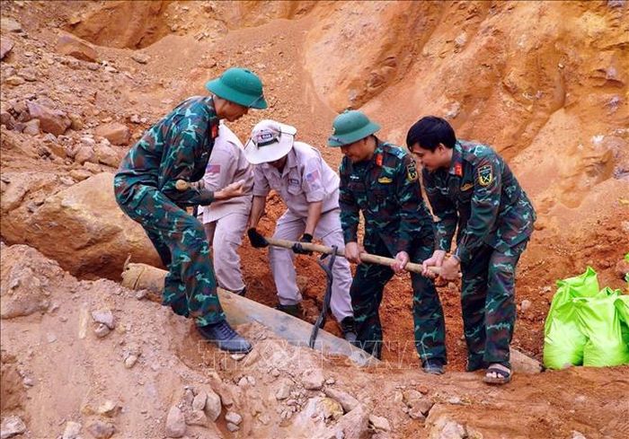 Đội xử lý bom mìn của MAG phối hợp Ban Chỉ huy Quân sự xã Bố Trạch xử lý an toàn quả bom để vận chuyển đi tiêu hủy. Ảnh: TTXVN phát