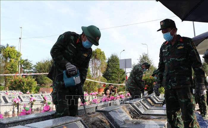 Lực lượng lấy mẫu hài cốt liệt sĩ thực hiện nhiệm vụ tại Nghĩa trang liệt sĩ Châu Thành (xã Phú Hựu). Ảnh: Hồng Thái/TTXVN