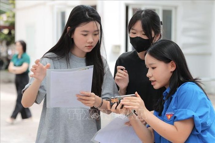 Tình nguyện viên hỗ trợ thí sinh đến làm thủ tục dự thi tại điểm thi Trường THPT Nguyễn Gia Thiều (Hà Nội). Ảnh: Minh Quyết/TTXVN