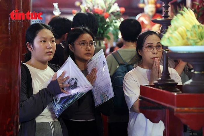 Nhiều học sinh mang theo giấy báo dự thi, hồ sơ và đồ dùng học tập khi tới Văn Miếu cầu may.