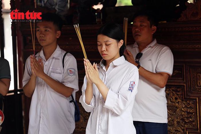Học sinh, phụ huynh và du khách dâng hương tại khu vực thờ các bậc tiên hiền, tiên triết ở Văn Miếu - Quốc Tử Giám.