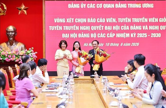 Đồng chí Nguyễn Thị Hoàng Vân, Phó Bí thư Đảng ủy các cơ quan Đảng Trung ương tặng hoa chúc mừng hai báo cáo viên được chọn tham gia Hội thi cấp khu vực phía Bắc. Ảnh: Minh Đức/TTXVN