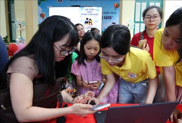 Phụ huynh học sinh hướng dẫn cho thiếu nhi cách sử dụng mạng xã hội và trí tuệ nhân tạo trên thiết bị di động, máy tính an toàn.